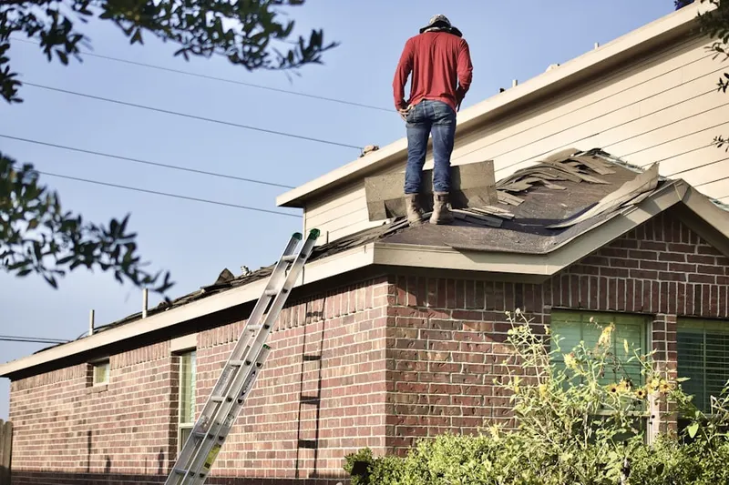 Professional roofer working on a residential roof in Highland Manor
